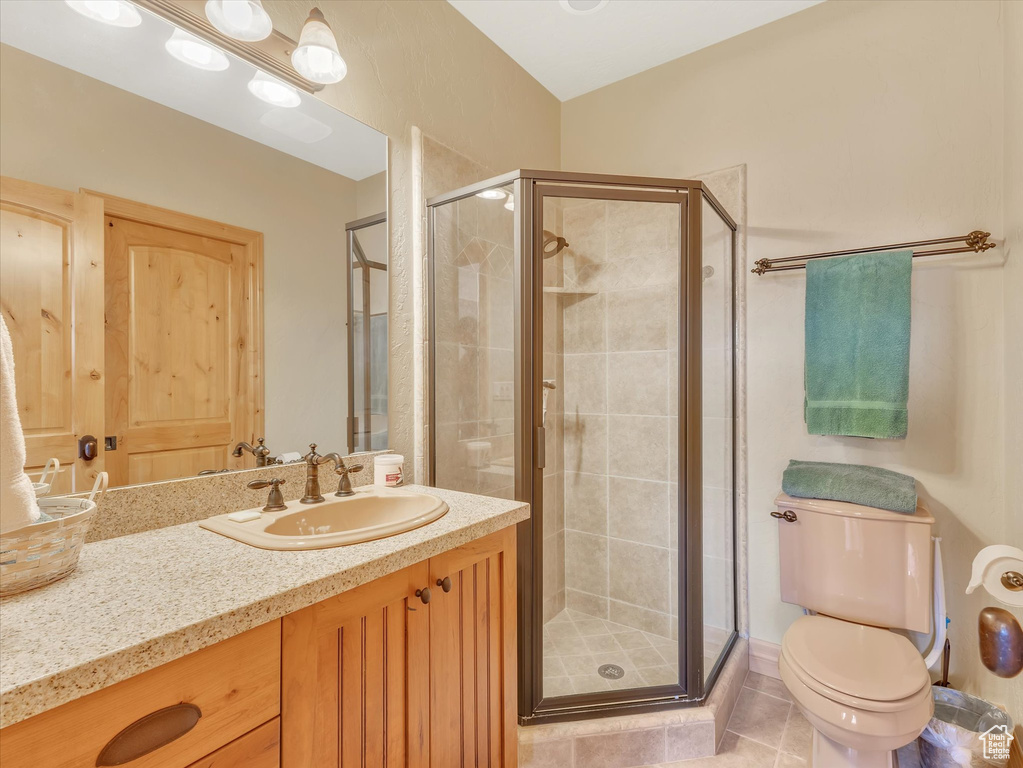 Full bath featuring vanity, a stall shower, and tile patterned floors