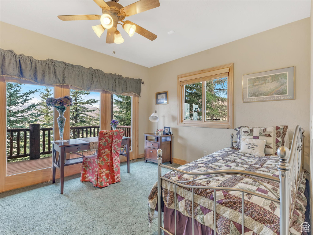 Carpeted bedroom with access to outside, multiple windows, and ceiling fan