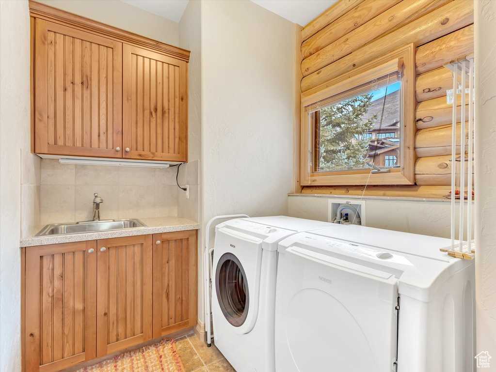 Laundry room featuring separate washer and dryer and cabinet space