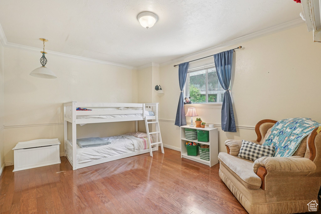 Bedroom featuring ornamental molding and wood finished floors