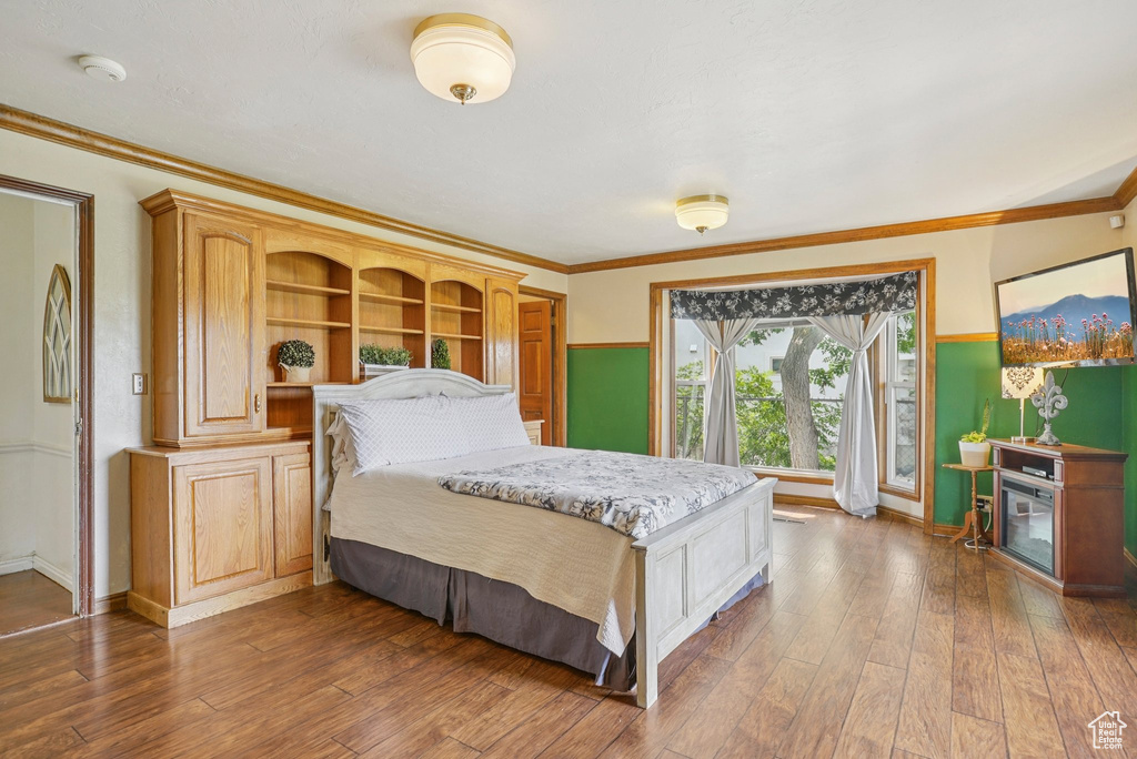 Bedroom featuring hardwood / wood-style flooring and ornamental molding
