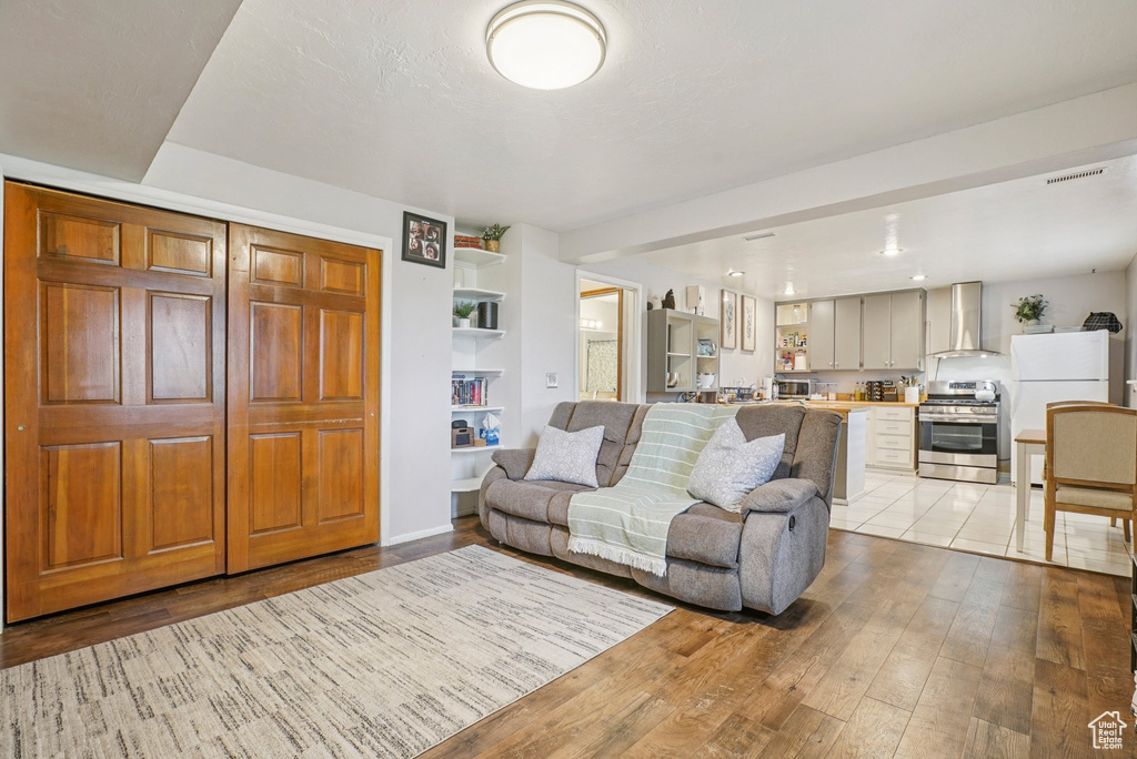 Living room with light wood-style floors and built in shelves