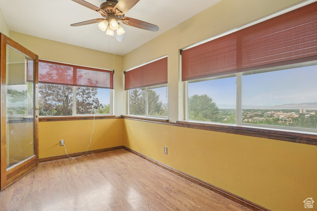 Unfurnished sunroom featuring wood finished floors and baseboards