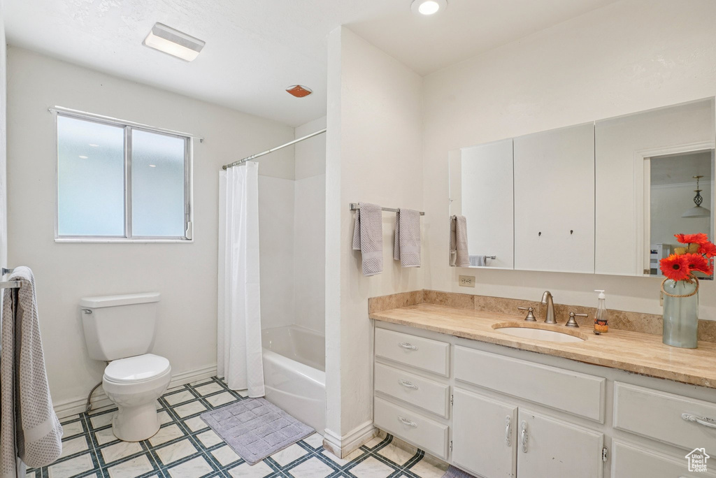 Bathroom featuring vanity, shower / bathtub combination with curtain, and tile patterned floors