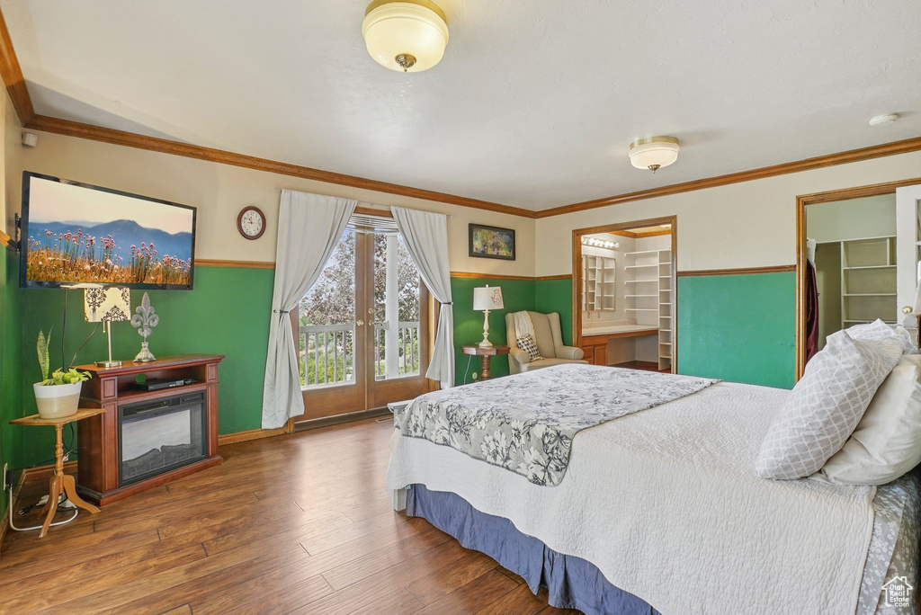 Bedroom with wood finished floors and crown molding