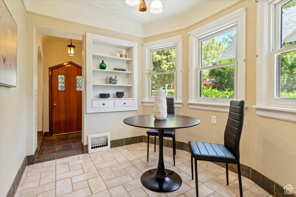 Dining area with stone tile floors, built in shelves, and arched walkways