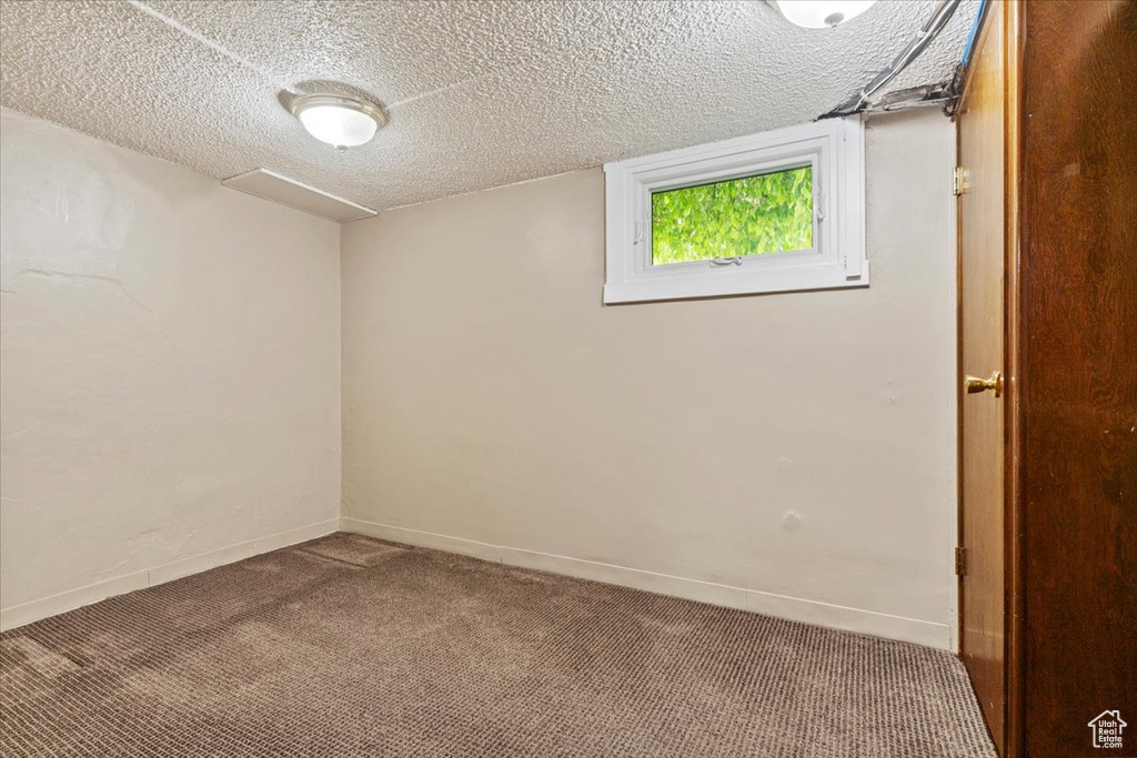 Carpeted empty room featuring a textured ceiling