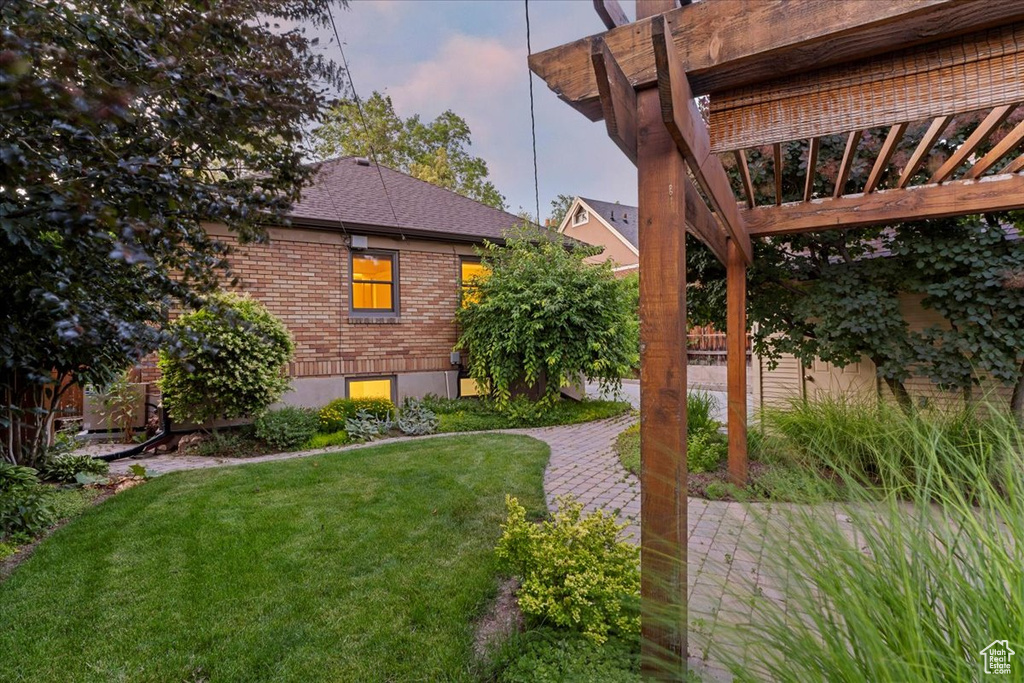 View of grassy yard with a patio area