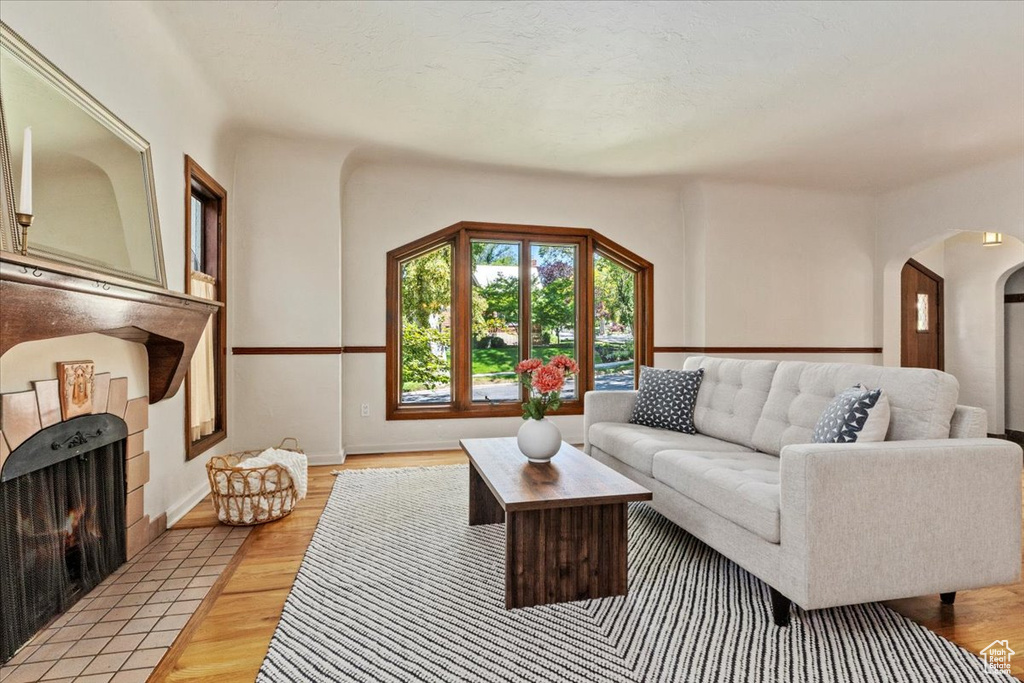 Living area featuring arched walkways and light wood-type flooring