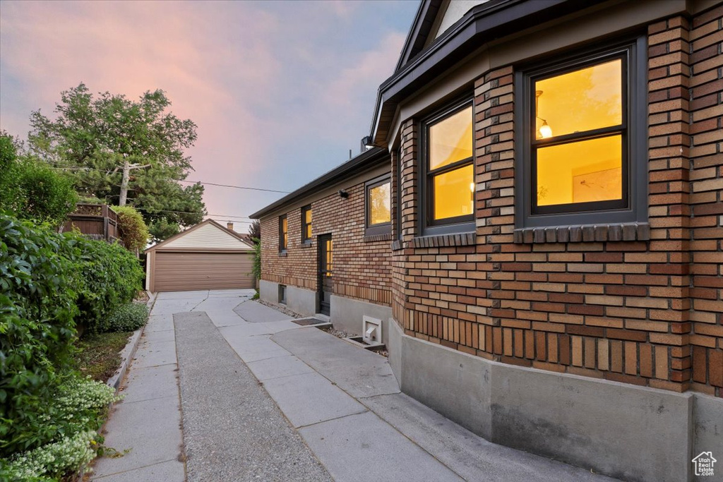 Property exterior at dusk with brick siding and an outbuilding