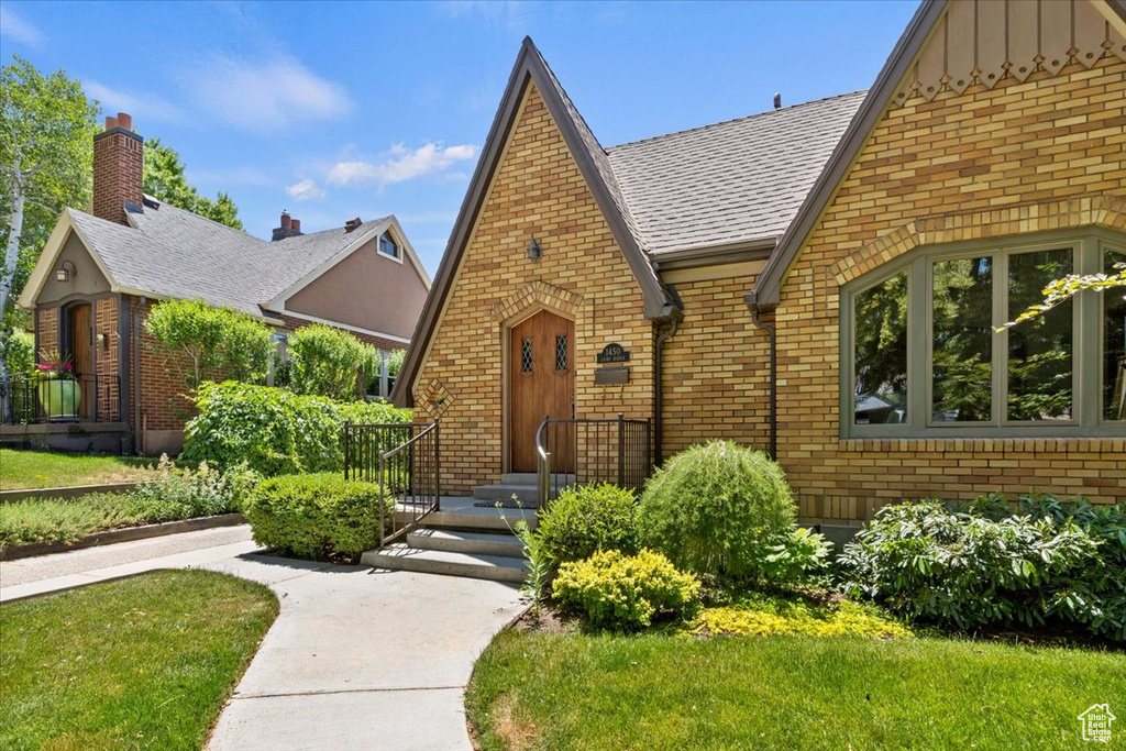 English style home with brick siding and board and batten siding