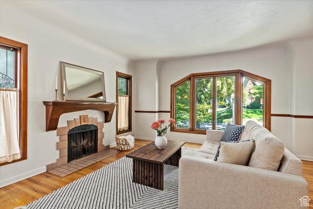 Living room with a tile fireplace and wood finished floors