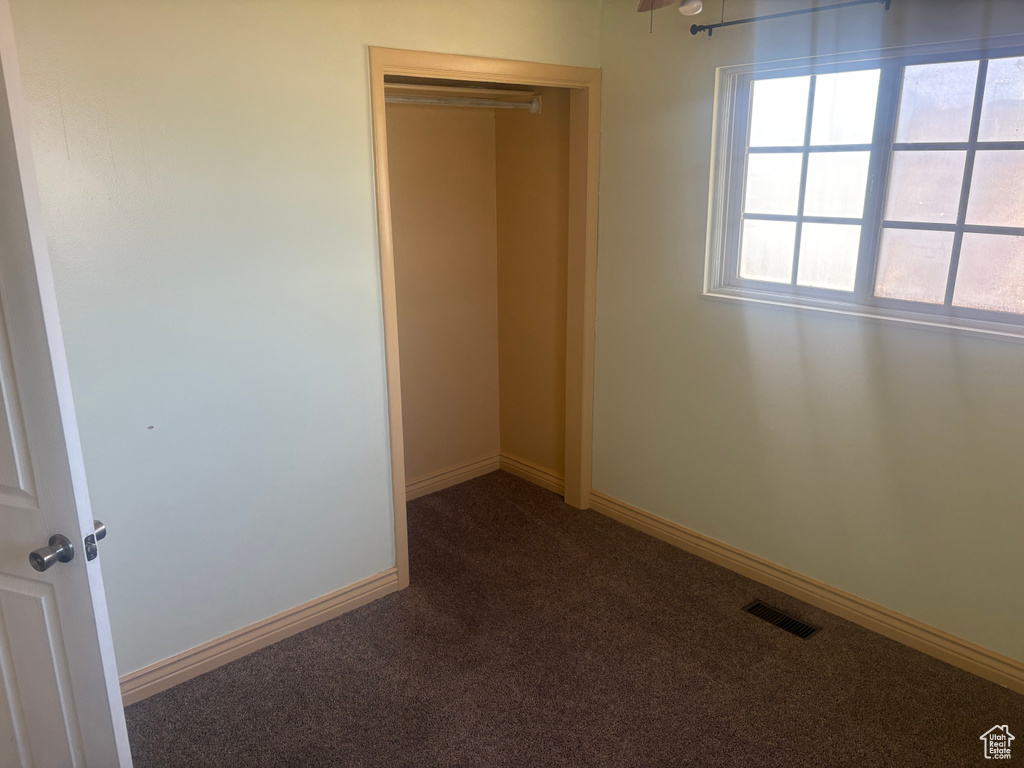 Unfurnished bedroom with carpet floors and baseboards
