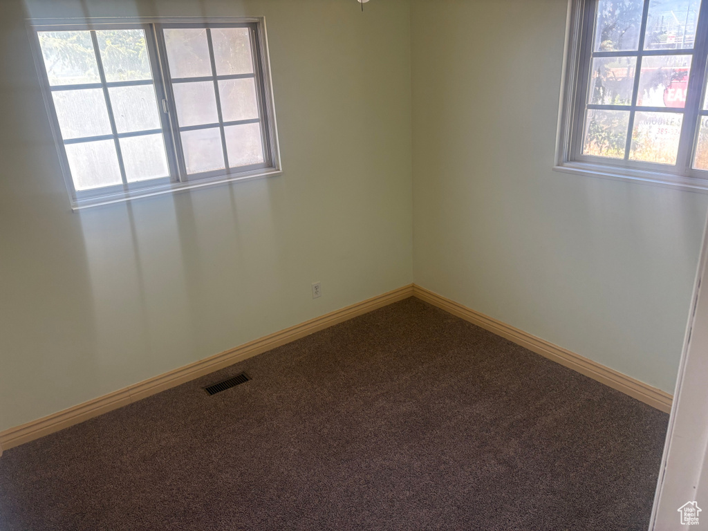 Empty room featuring carpet and baseboards