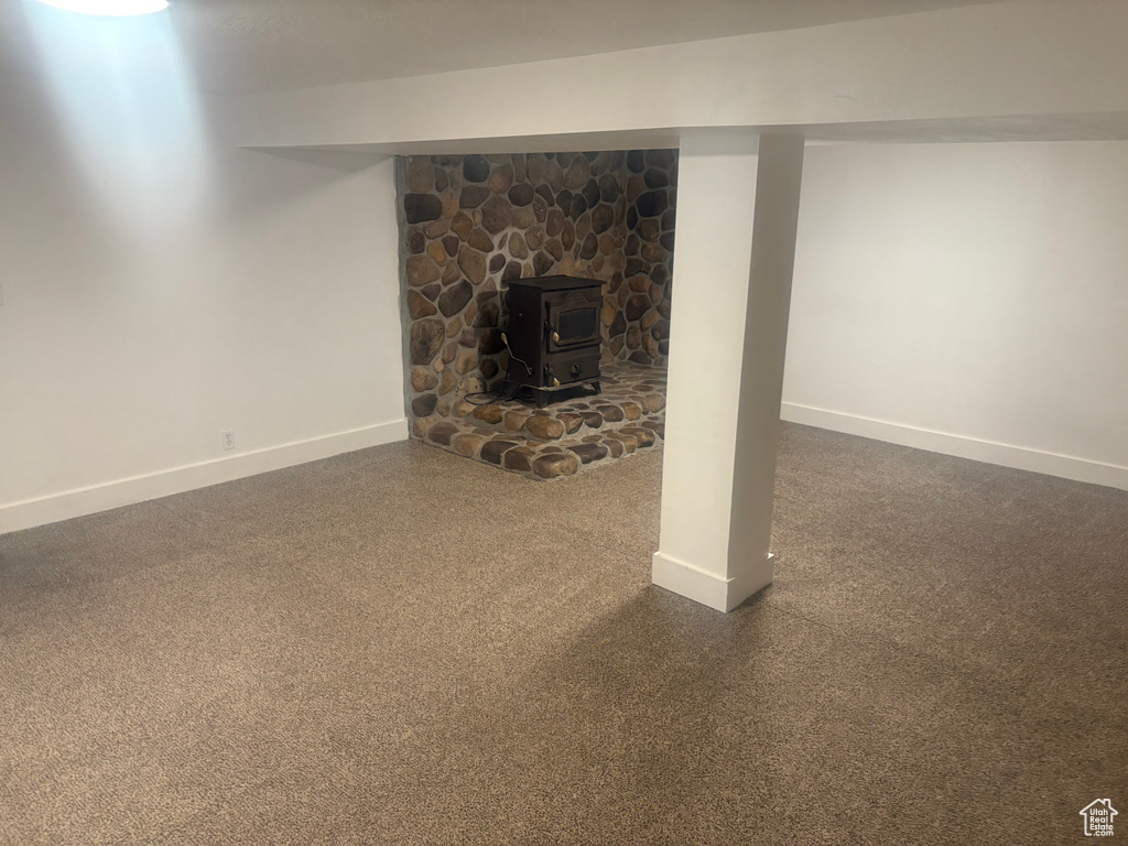 Finished below grade area with baseboards and a wood stove