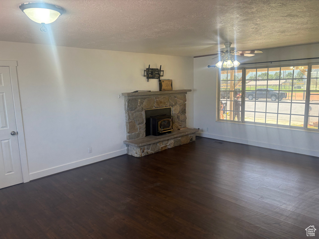 Unfurnished living room with a textured ceiling, a ceiling fan, and wood finished floors