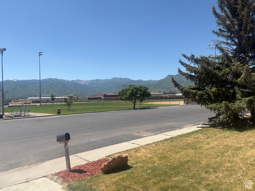 View of asphalt road with a mountain view and street lighting