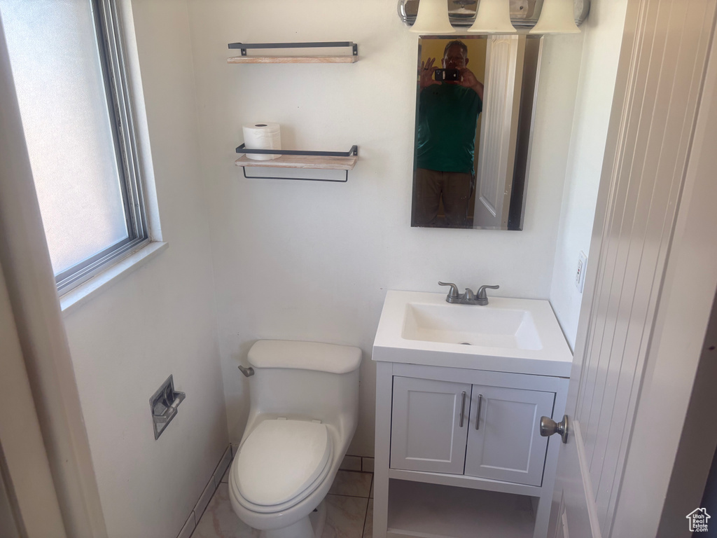 Half bathroom featuring vanity and toilet
