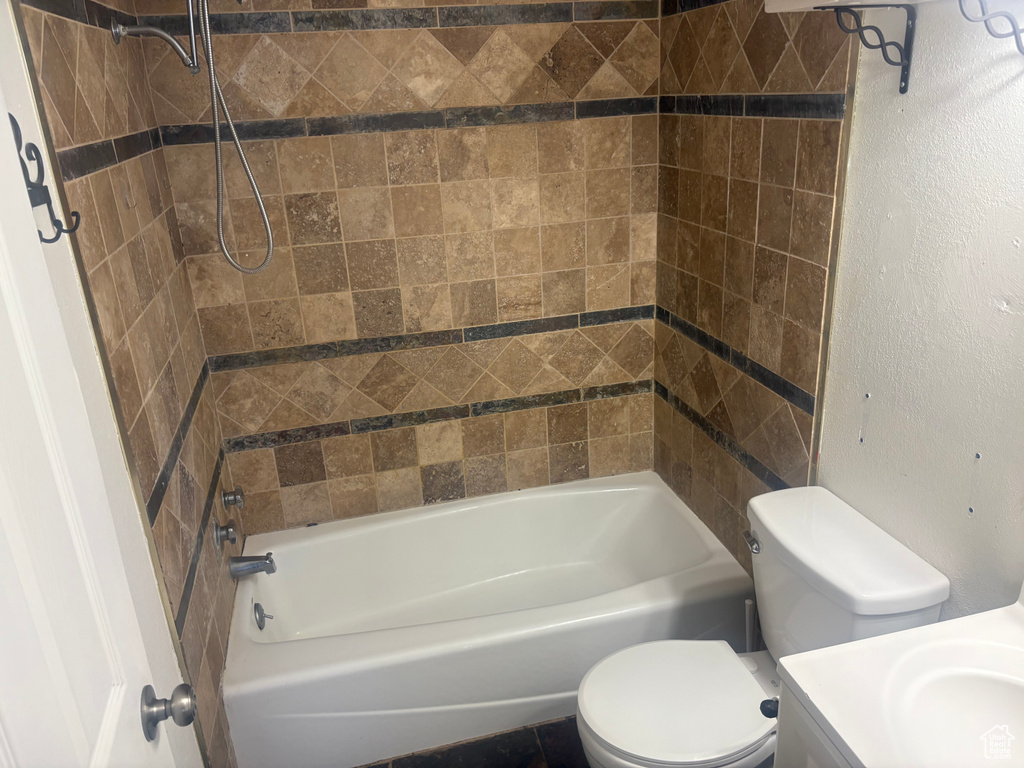 Bathroom with vanity, bathing tub / shower combination, and a textured wall