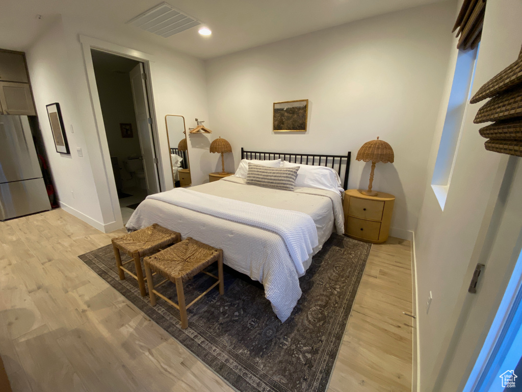 Bedroom featuring freestanding refrigerator, light wood finished floors, and recessed lighting