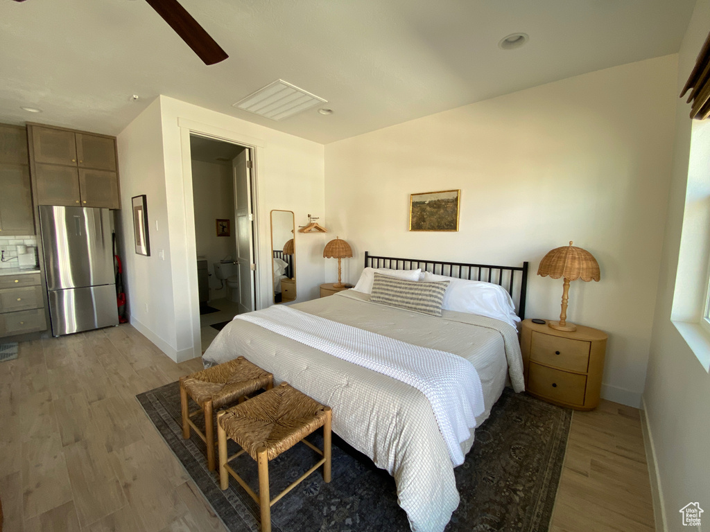 Bedroom featuring freestanding refrigerator, light wood-style flooring, ceiling fan, recessed lighting, and connected bathroom