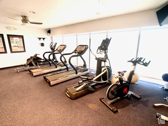 Workout area with a ceiling fan and baseboards