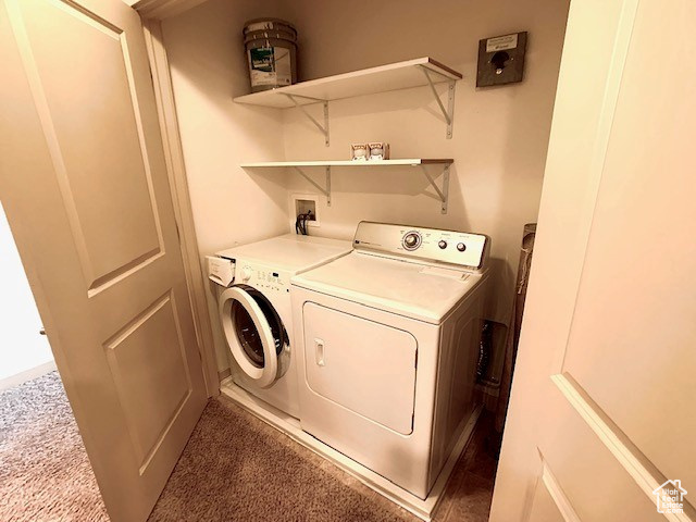 Laundry room with washer and dryer and carpet flooring
