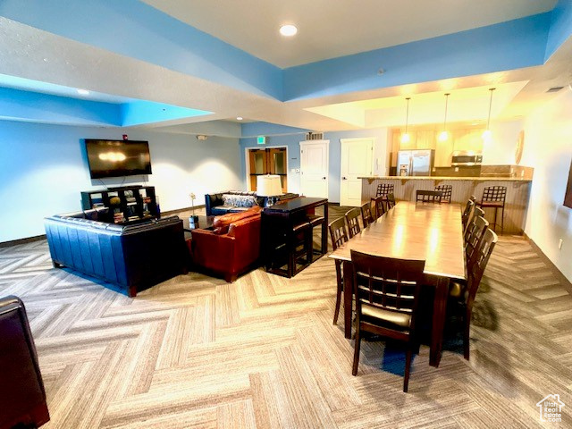 Dining area featuring carpet, a raised ceiling, and recessed lighting