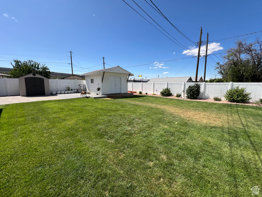 Fenced backyard featuring a shed and a patio area