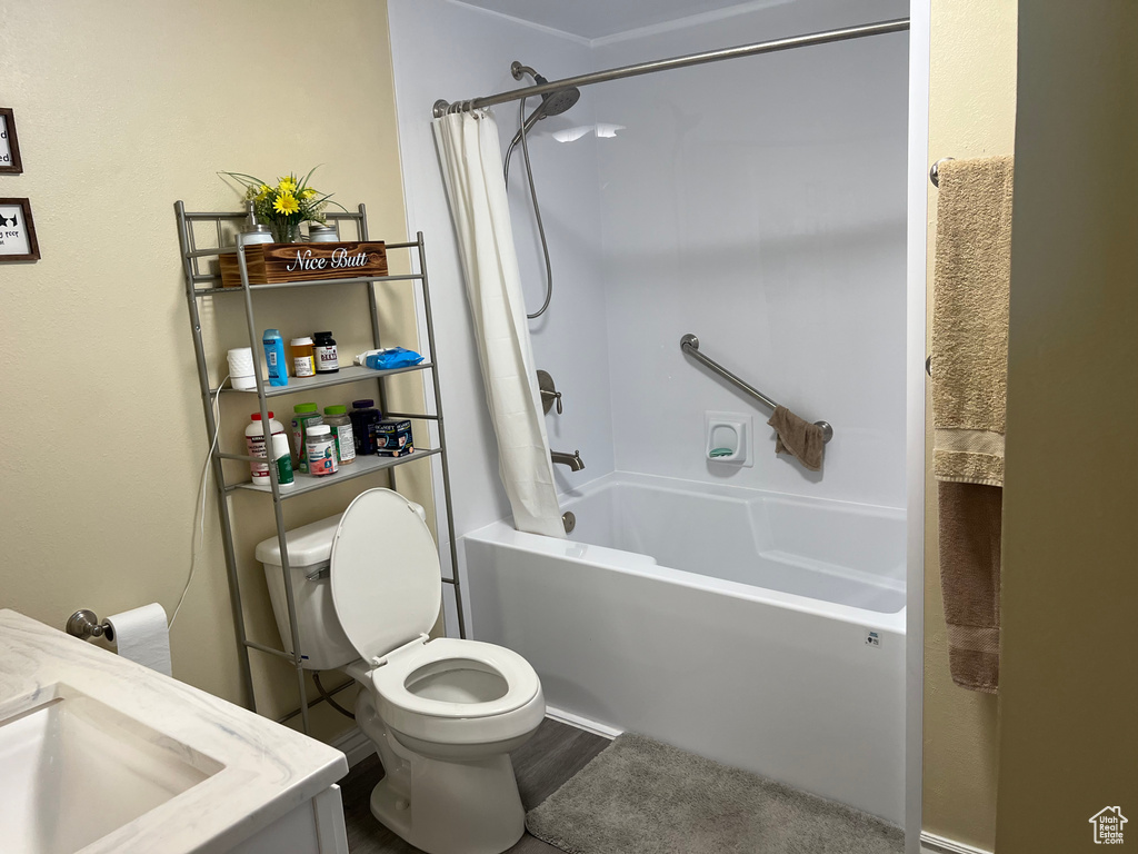 Full bathroom with shower / bath combo with shower curtain, vanity, and wood finished floors