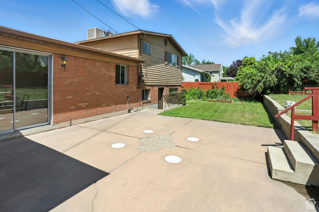 Rear view of house with brick siding and a patio