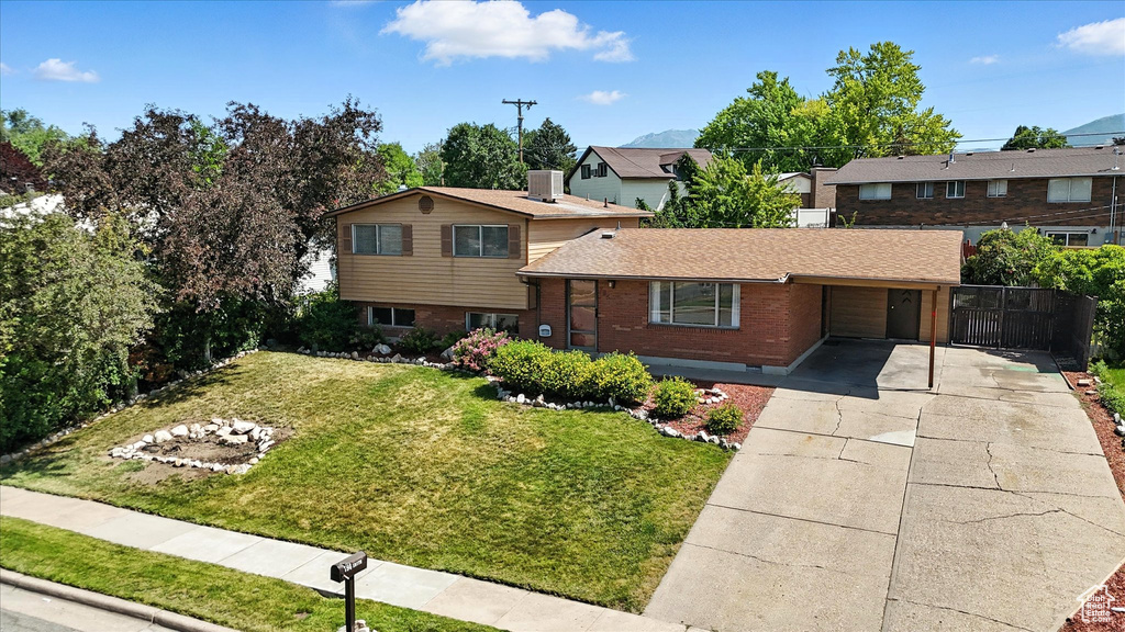 View of front facade with concrete driveway, brick siding, and a shingled roof