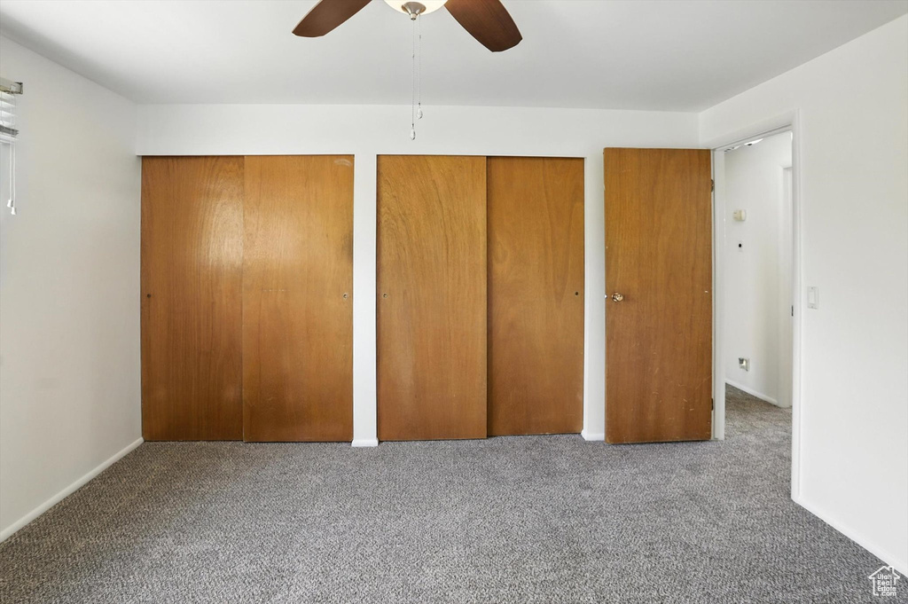 Unfurnished bedroom with two closets, carpet floors, and a ceiling fan