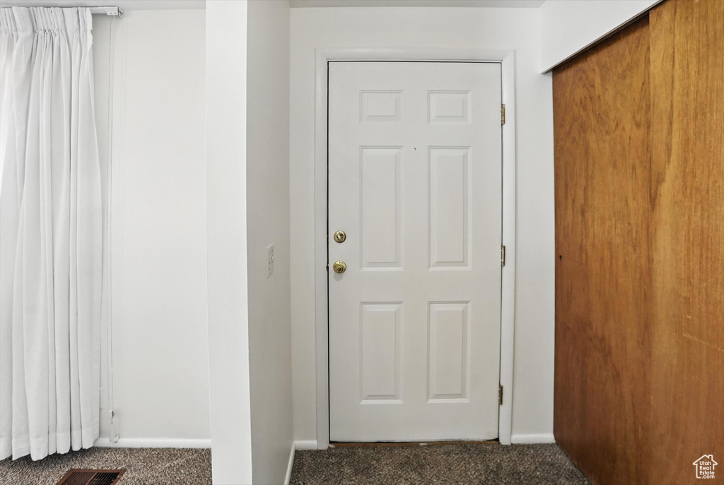 Entryway with carpet flooring and baseboards