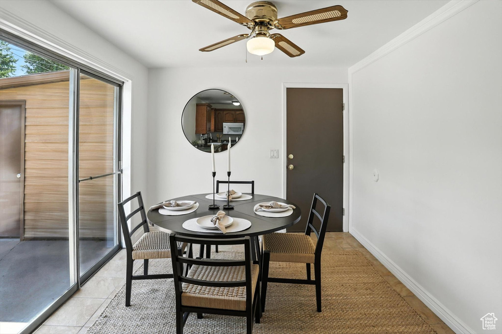 Dining space with ceiling fan and light tile patterned flooring