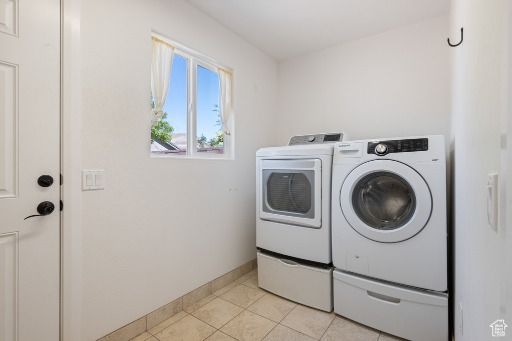 Laundry area featuring independent washer and dryer and light tile patterned floors