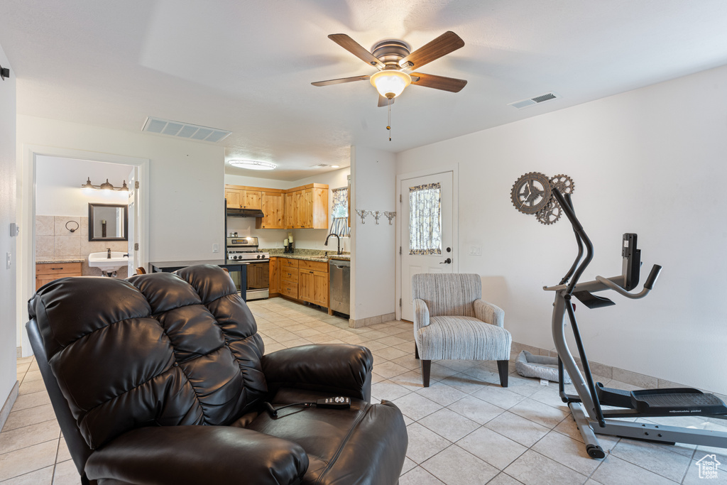Living room with light tile patterned floors and a ceiling fan