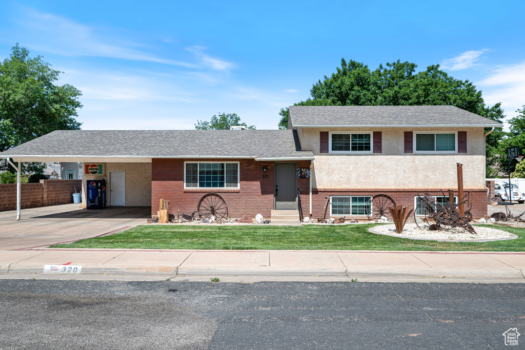 View of front of home featuring concrete driveway, a carport, brick siding, and entry steps