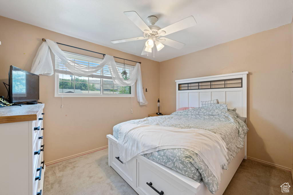 Bedroom with light colored carpet and ceiling fan