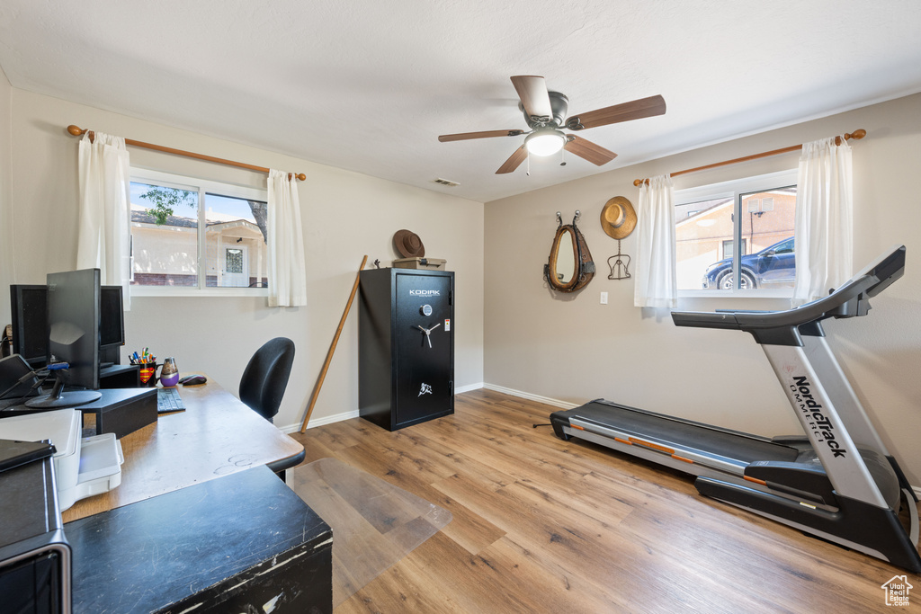 Office area with ceiling fan, plenty of natural light, and wood finished floors