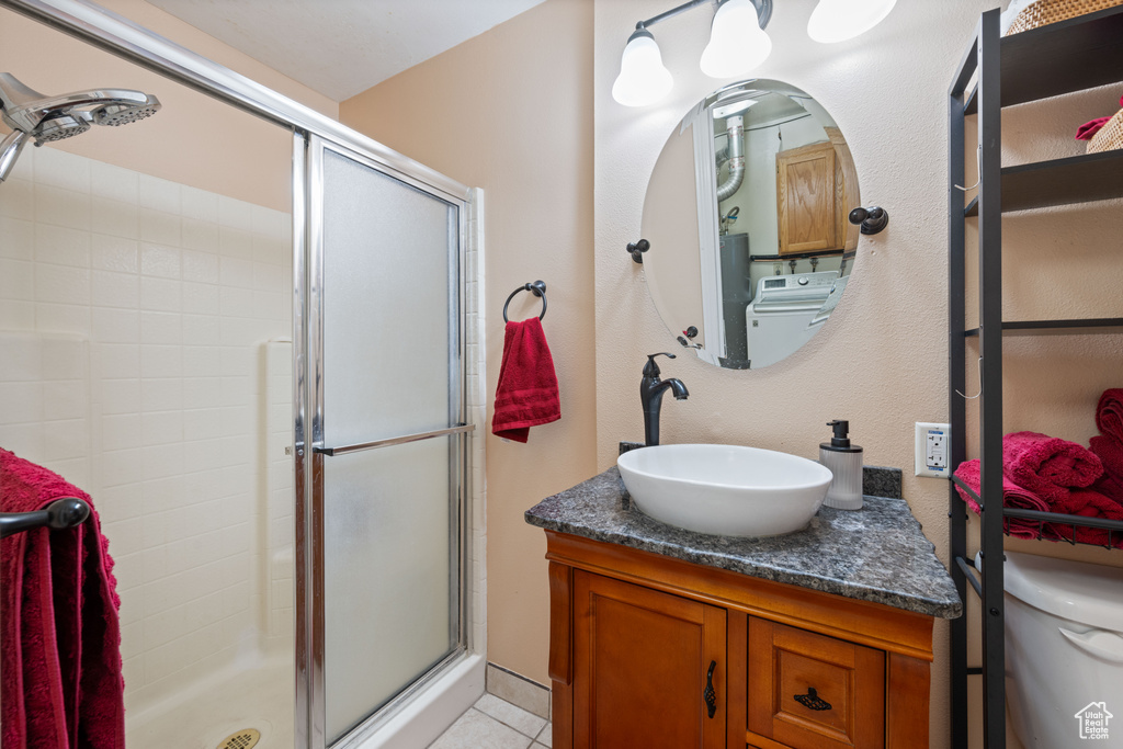 Bathroom featuring a stall shower, vanity, and tile patterned floors