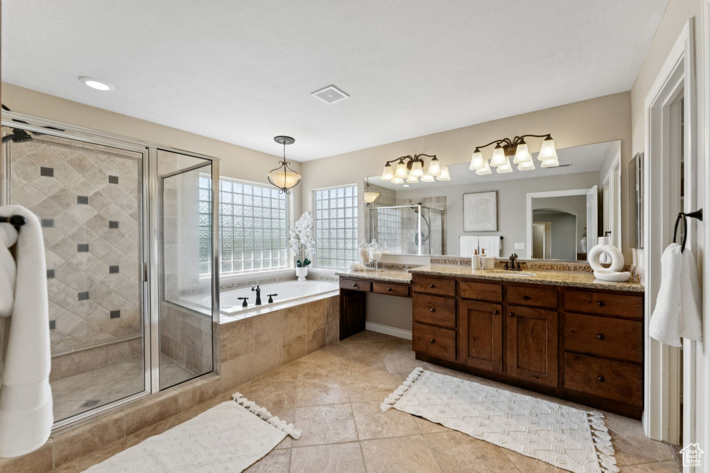 Bathroom featuring vanity, a bath, a stall shower, and tile patterned floors