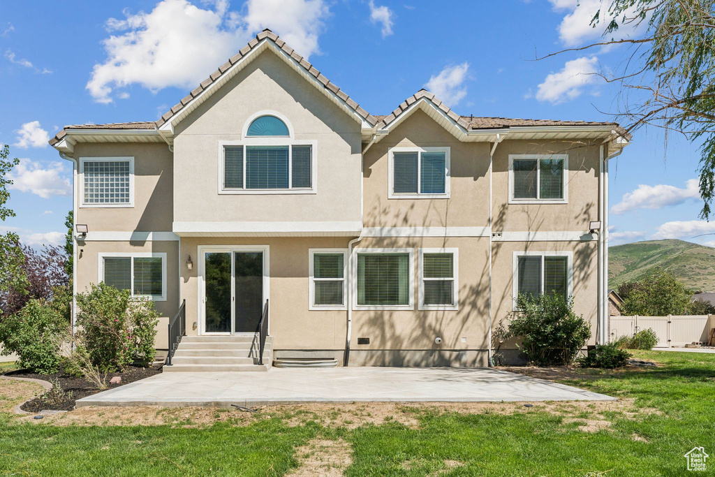 Back of house with a patio area, stucco siding, and entry steps