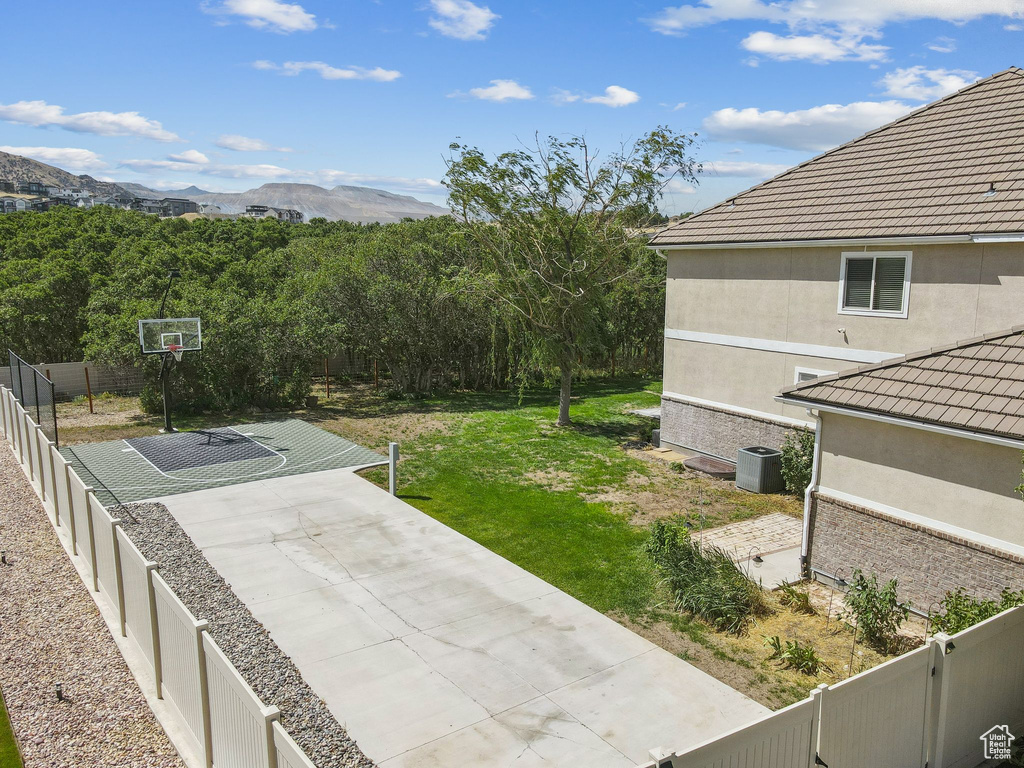 Fenced backyard featuring a mountain view and basketball court