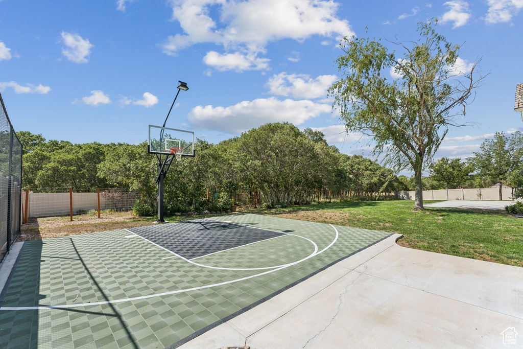 View of sport court featuring basketball hoop and a fenced backyard