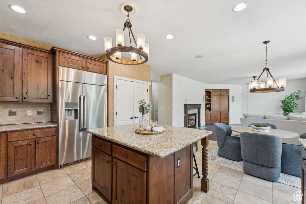 Kitchen with built in refrigerator, a chandelier, open floor plan, decorative light fixtures, and recessed lighting