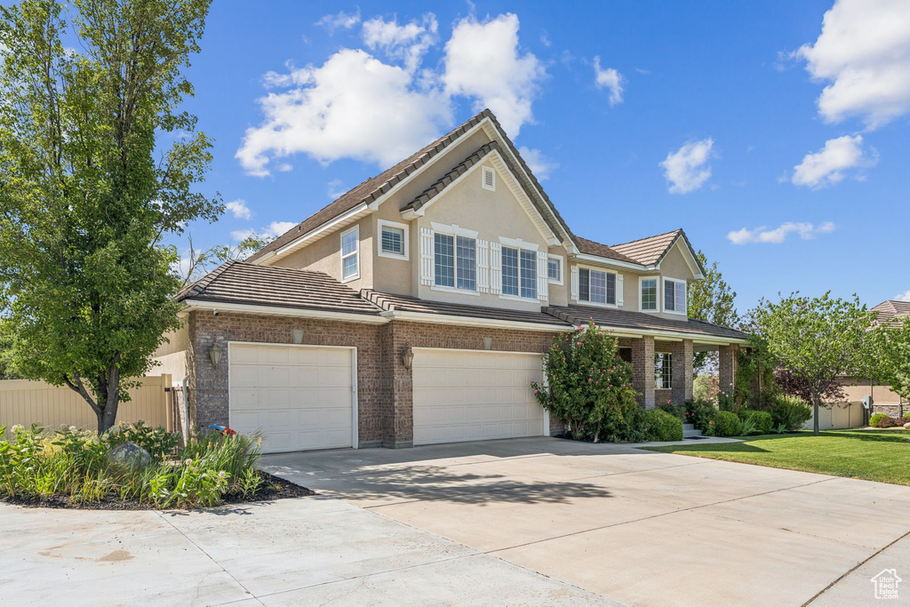 View of front of home featuring concrete driveway, a tile roof, an attached garage, and stucco siding