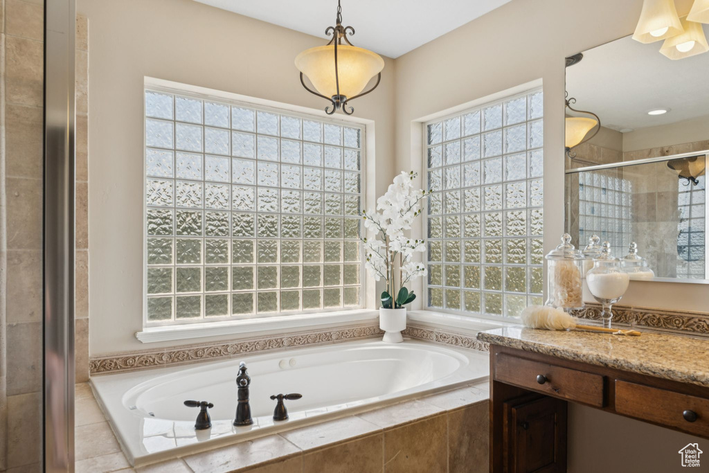 Bathroom with healthy amount of natural light, a bath, and a stall shower