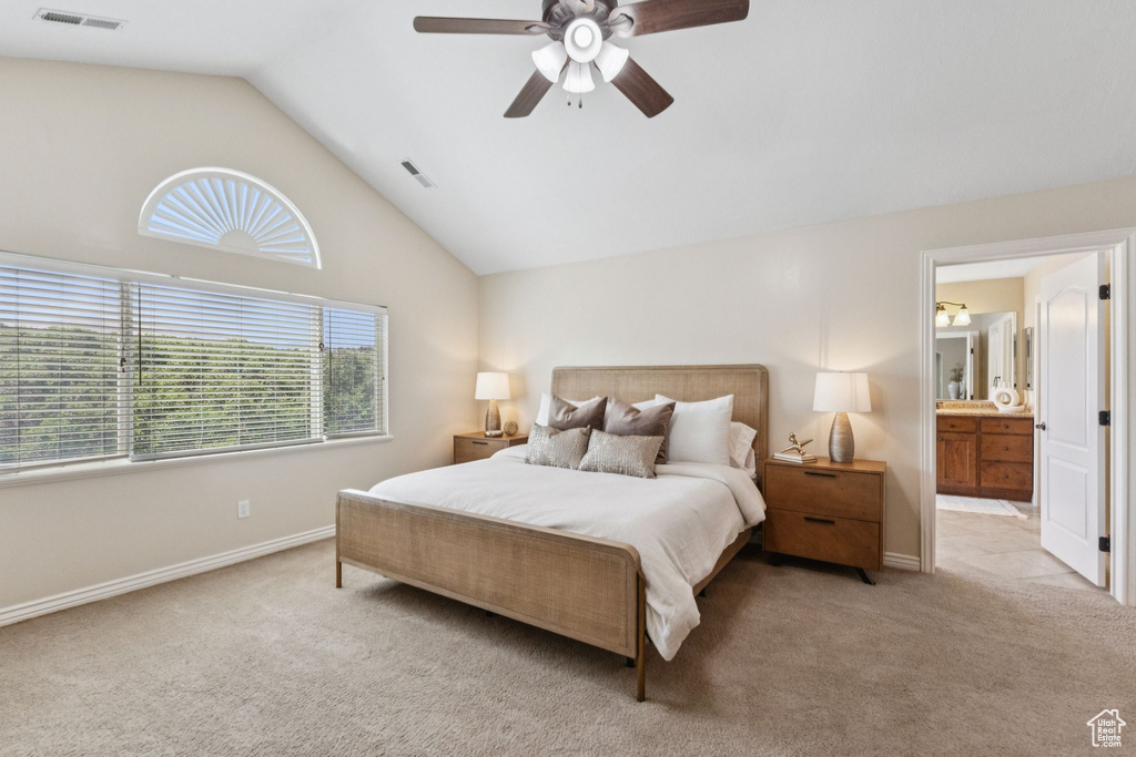 Carpeted bedroom featuring lofted ceiling, a ceiling fan, and ensuite bath