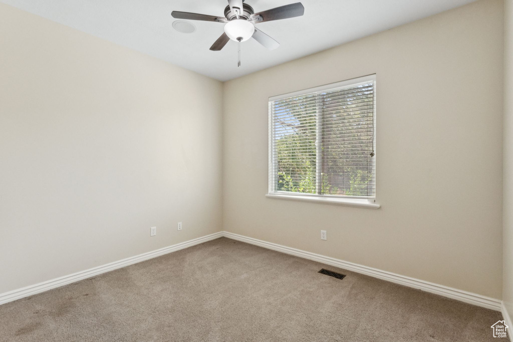 Spare room with carpet and a ceiling fan